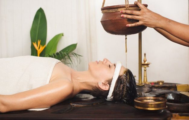 Caucasian woman having Ayurveda shirodhara treatment in India