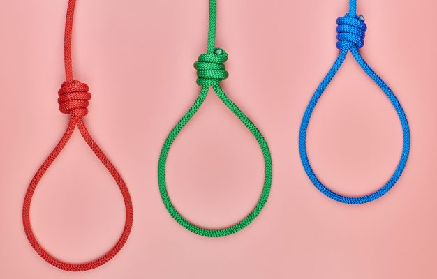 Three hangman’s knots Three hangman's knots. Incitement to suicide or death penalty concept. Red, green and blue braided hanging noose tied the knot.